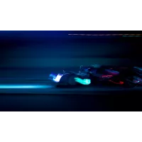 An action shot of a racecar in the dark, with motion blur, at night time, with blue and purple lights, on a black background, with a long exposure, in a cinematic style, with professional photography techniques.